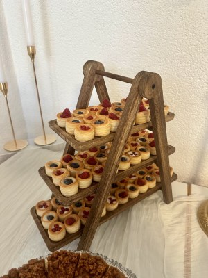 Holzetagere mit Dessertgläsern und kleinen Törtchen